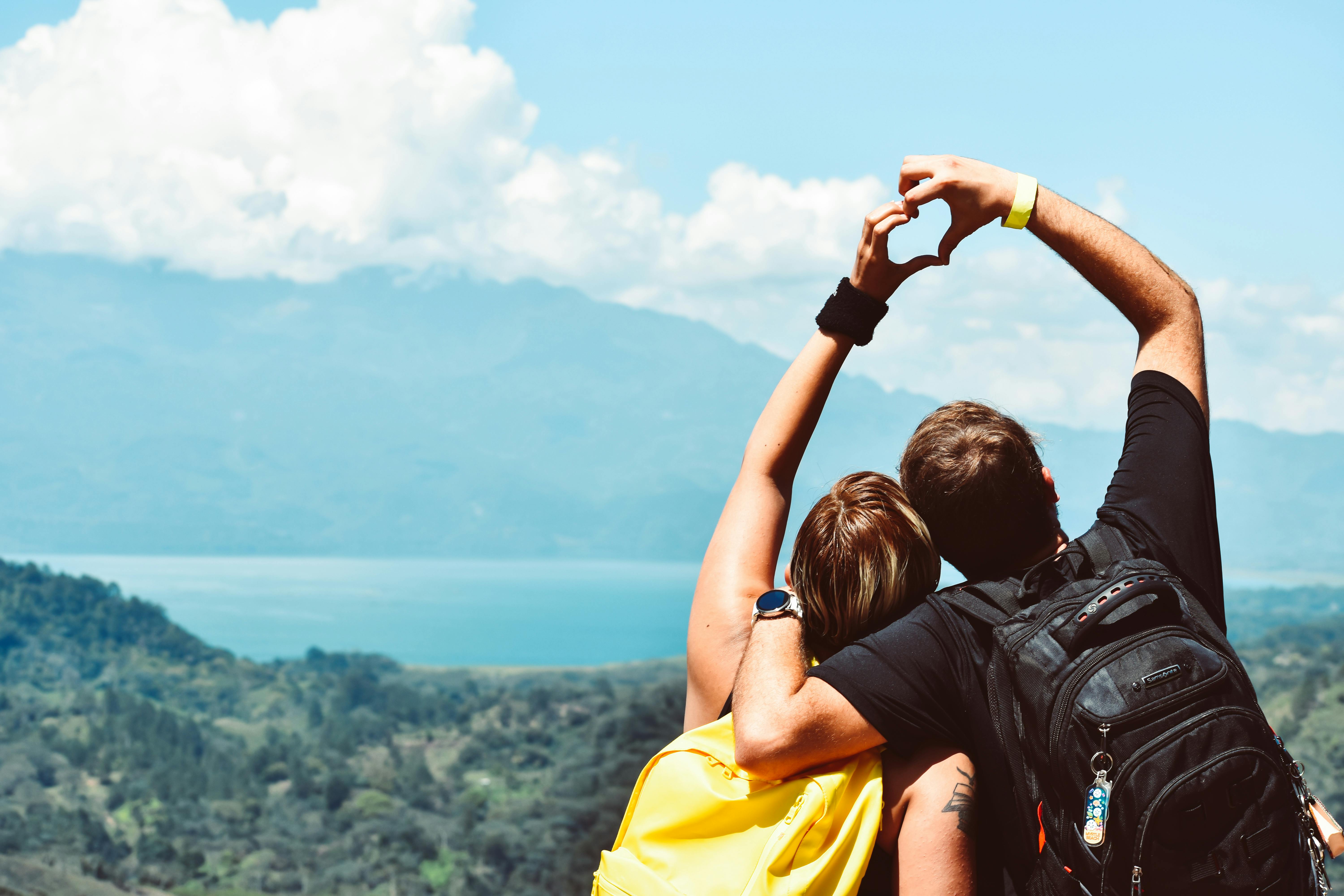 Couple qui fait un signe de coeur avec leurs main et qui ont réservé une love room